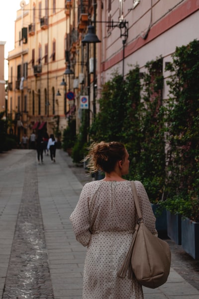 Women dressed in black and white dot long sleeve shirt day for a walk on the sidewalk
